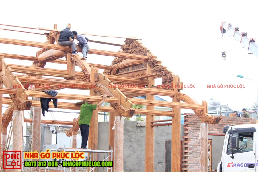 Hình ảnh người thợ đang lắp dựng khung nhà gỗ