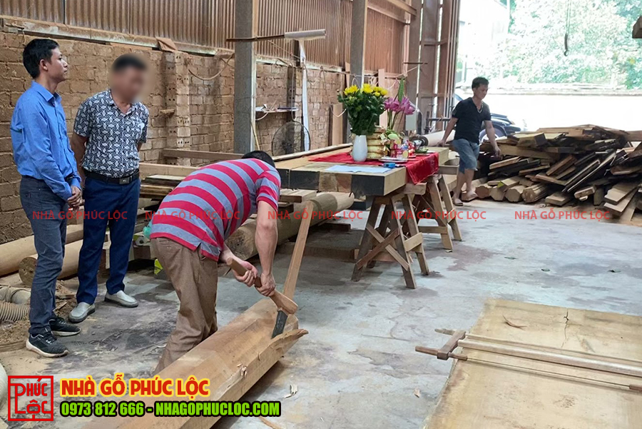 Bác thợ thực hiện việc lấy rìu đẽo vào cột nhà gỗ lim 5 gian 