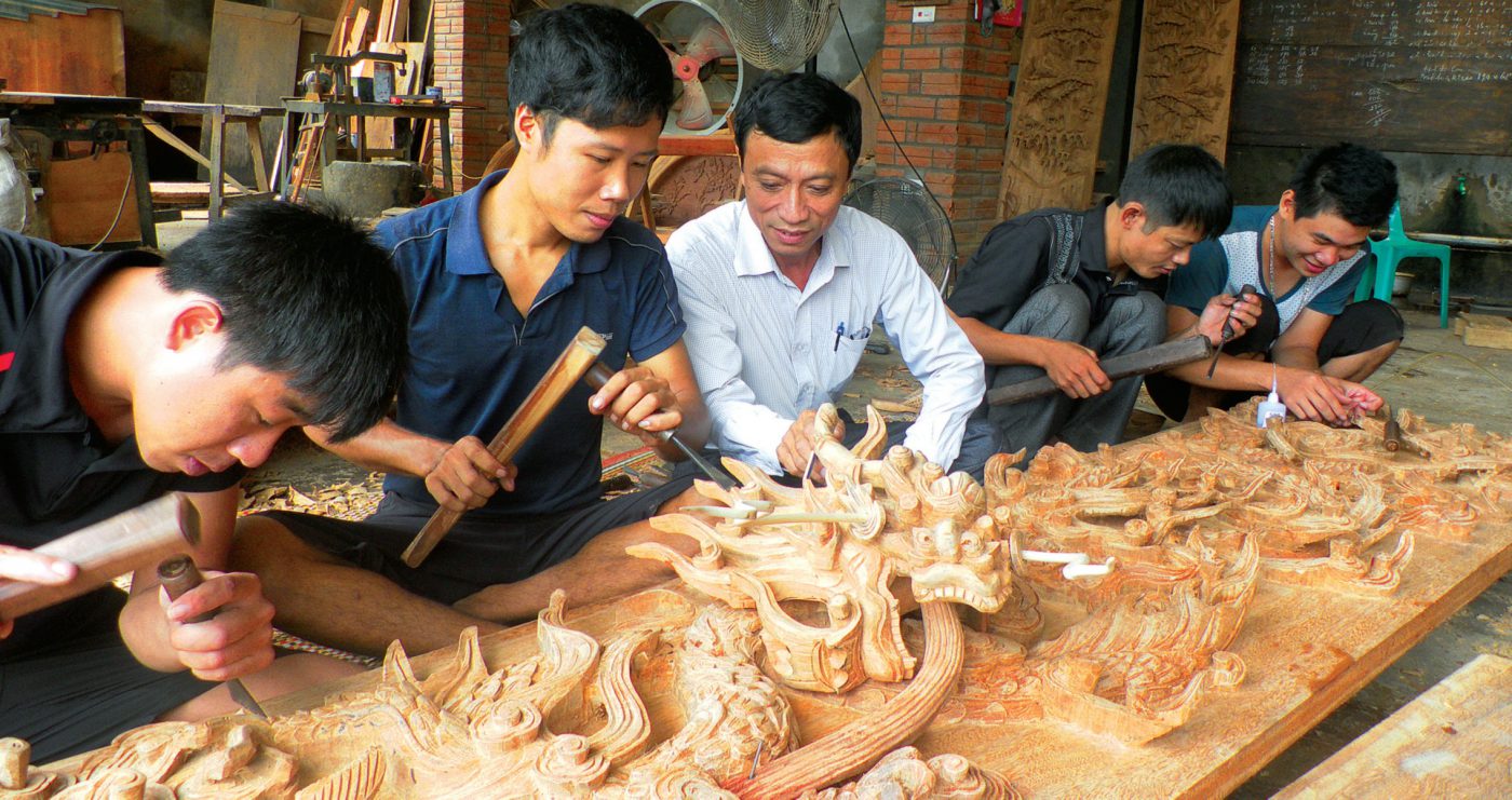 Nghệ nhân Nguyễn Khắc Tiến (áo trắng) đang truyền dạy nghề cho các thế hệ trẻ.